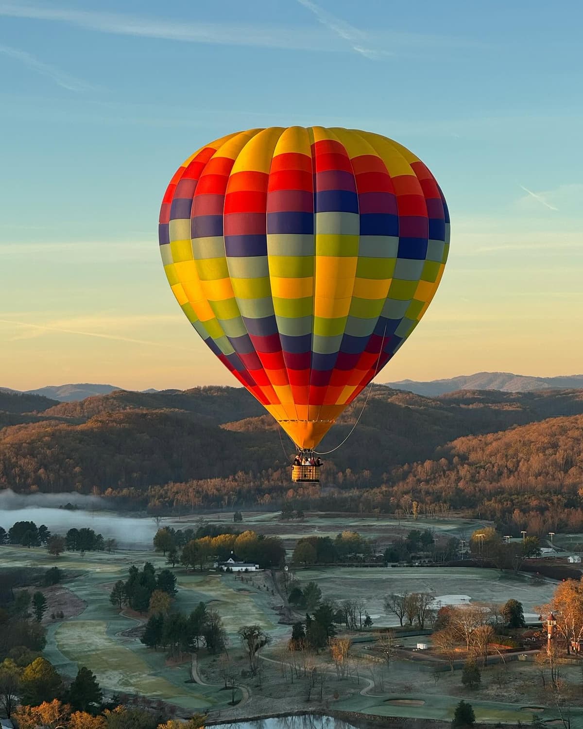 Colorful hot air balloon floating safely over Blue Ridge Mountains