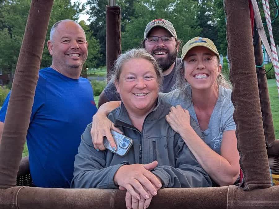 Mandy, Holly, and crew smiling from the balloon basket after a flight